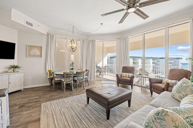 living room with a textured ceiling, crown molding, ceiling fan with notable chandelier, and wood-type flooring