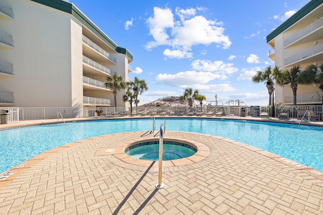 view of pool with a hot tub