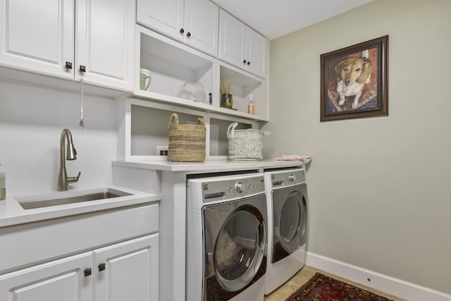 washroom featuring sink, washing machine and dryer, cabinets, and light tile patterned floors