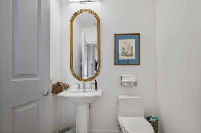 bathroom featuring crown molding and toilet