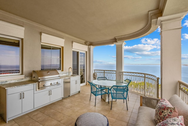 view of patio / terrace featuring a water view, sink, grilling area, area for grilling, and a balcony