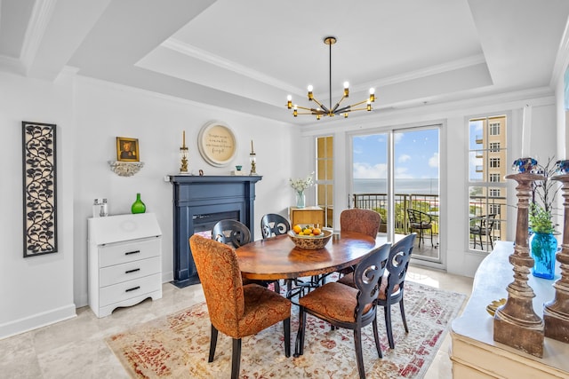 tiled dining area featuring ornamental molding, an inviting chandelier, and a tray ceiling