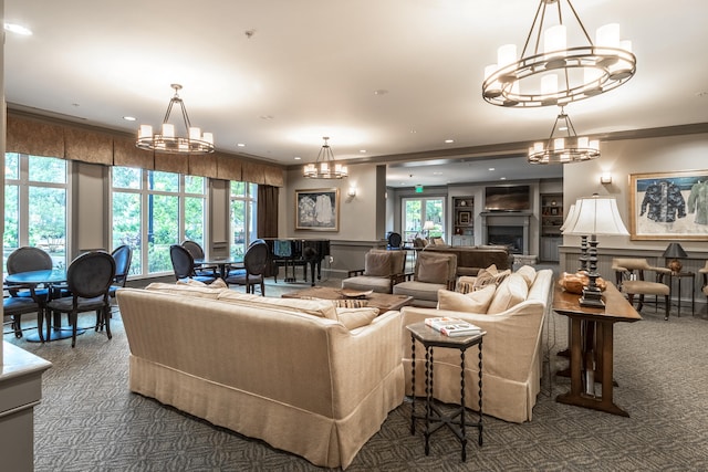 carpeted living room with ornamental molding and an inviting chandelier