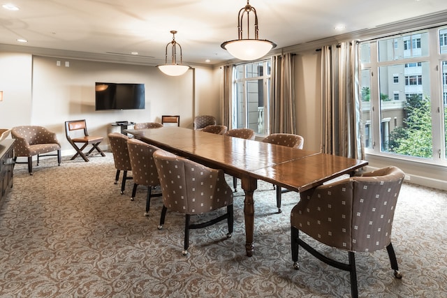 carpeted dining room with ornamental molding