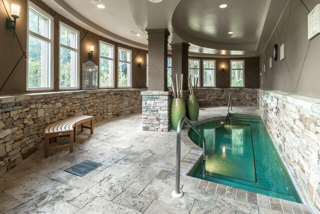 view of pool with ornate columns and an indoor hot tub