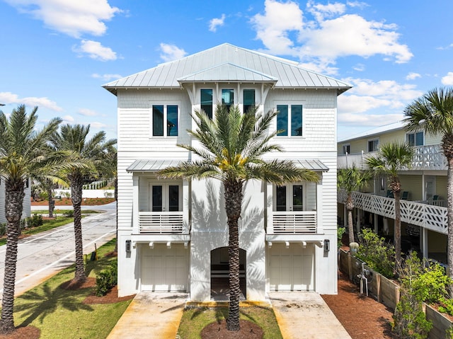 raised beach house featuring a balcony and a garage