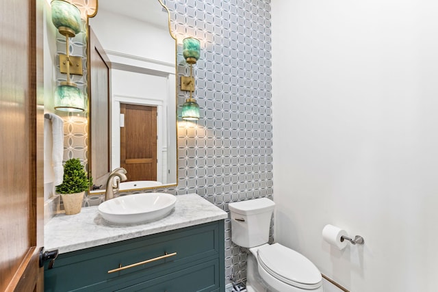 bathroom featuring vanity with extensive cabinet space, toilet, and tile walls