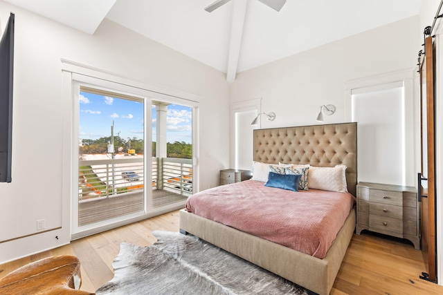 bedroom with ceiling fan, a barn door, vaulted ceiling with beams, light hardwood / wood-style floors, and access to outside