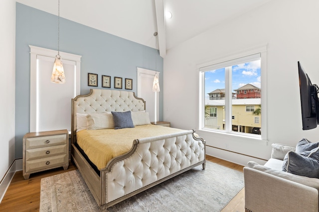 bedroom with lofted ceiling with beams and wood-type flooring