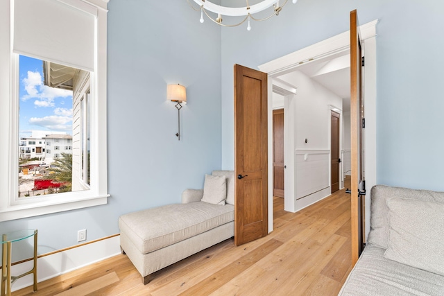 living area with light hardwood / wood-style floors and a notable chandelier