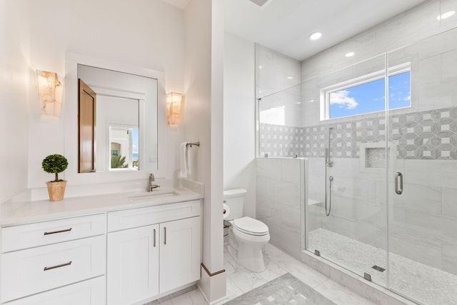 bathroom featuring vanity with extensive cabinet space, a shower with shower door, tile floors, and toilet