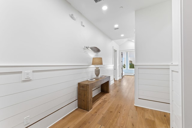 hall with vaulted ceiling and light wood-type flooring