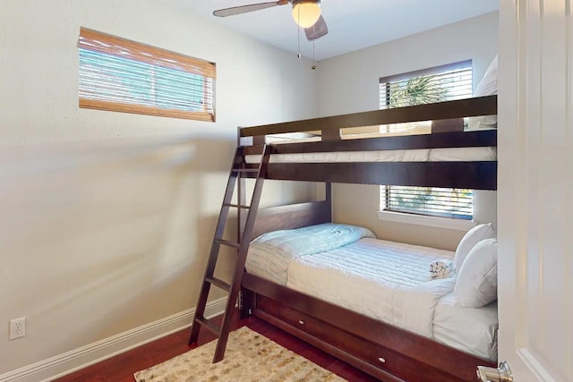 bedroom with dark hardwood / wood-style flooring, multiple windows, and ceiling fan