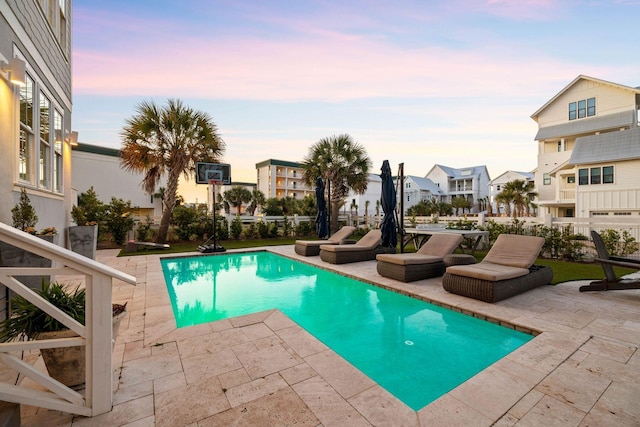 pool at dusk featuring a patio area