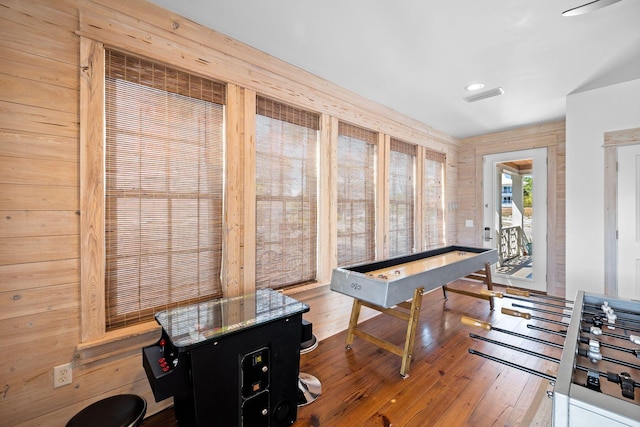 game room featuring wooden walls and hardwood / wood-style floors