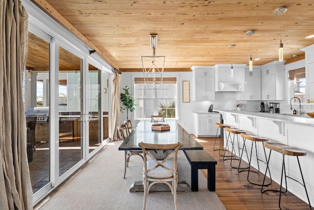 dining area with hardwood / wood-style floors, sink, french doors, and wood ceiling