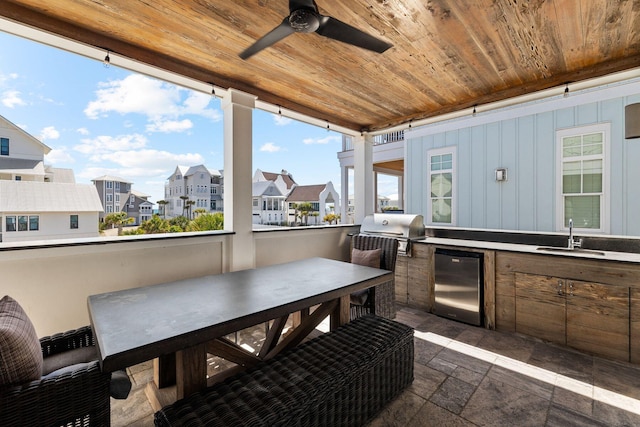 view of terrace with a grill, sink, ceiling fan, and an outdoor kitchen