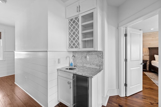 bar with sink, white cabinetry, and dark wood-type flooring