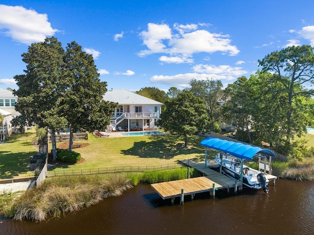 dock area featuring a water view, a yard, and a fenced in pool