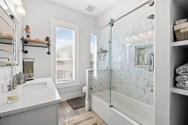 full bathroom featuring shower / bath combination with glass door, vanity, and toilet