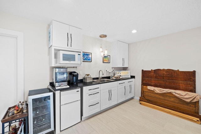 bar featuring decorative light fixtures, white microwave, wine cooler, white cabinets, and sink