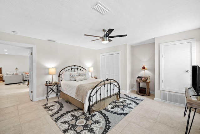 tiled bedroom featuring a closet, ceiling fan, and a textured ceiling