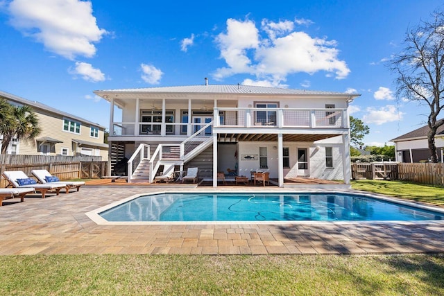 back of property featuring a patio area, a lawn, and a fenced in pool