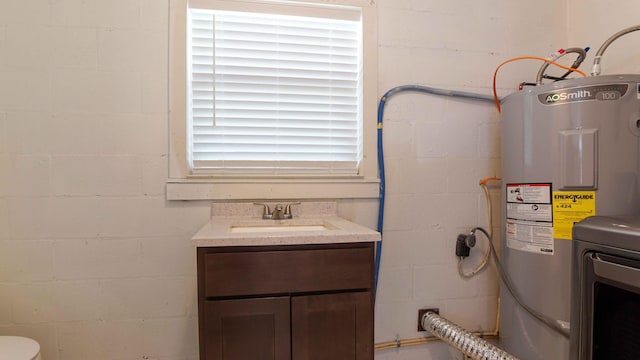 bathroom featuring water heater, vanity, and toilet