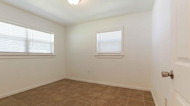 spare room with dark tile floors