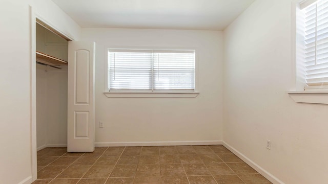 unfurnished bedroom featuring a closet and light tile floors