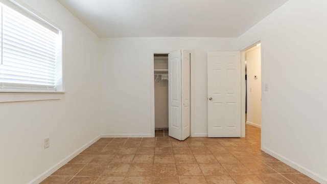 unfurnished bedroom with a closet and light tile floors