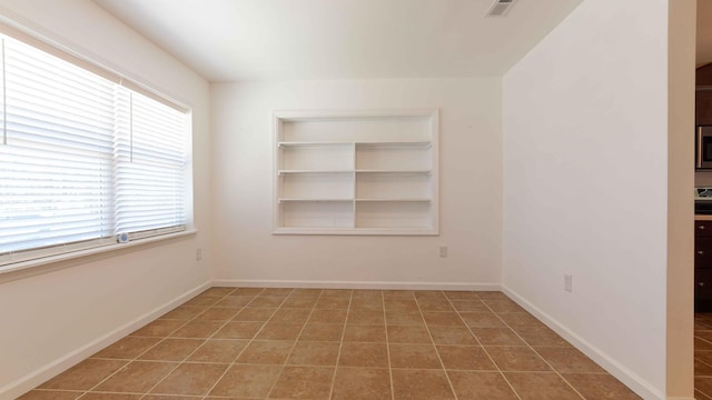 spare room with tile floors and a wealth of natural light