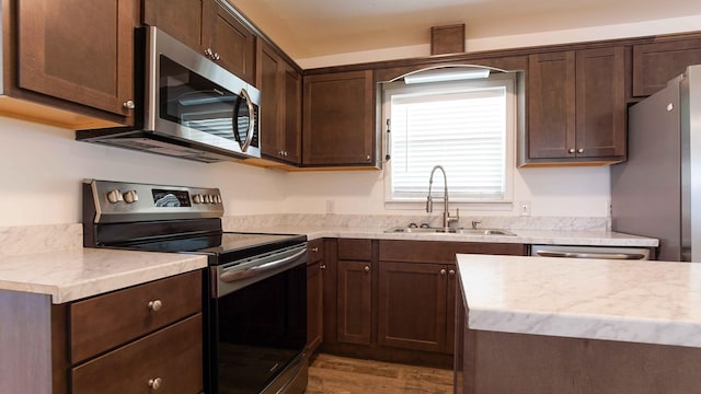 kitchen with dark brown cabinetry, dark hardwood / wood-style flooring, sink, and stainless steel appliances