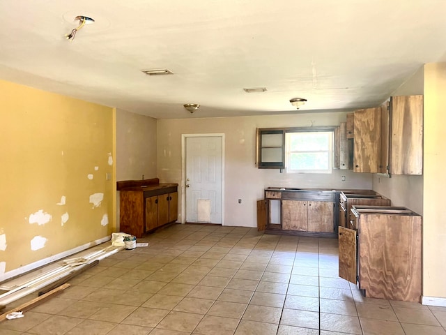 kitchen featuring stainless steel counters and light tile flooring