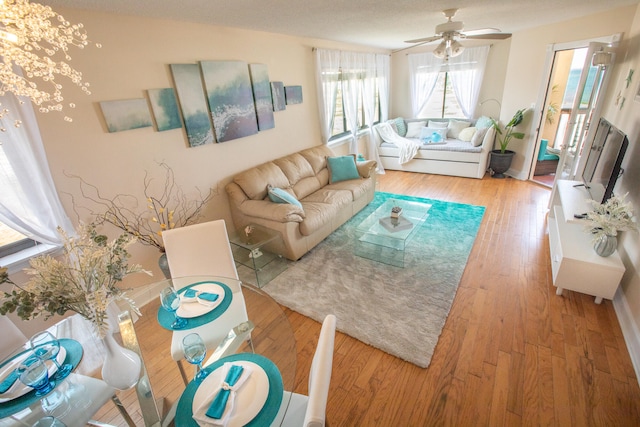 living room with ceiling fan and light wood-type flooring