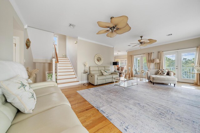 living room featuring crown molding, french doors, light hardwood / wood-style flooring, and ceiling fan