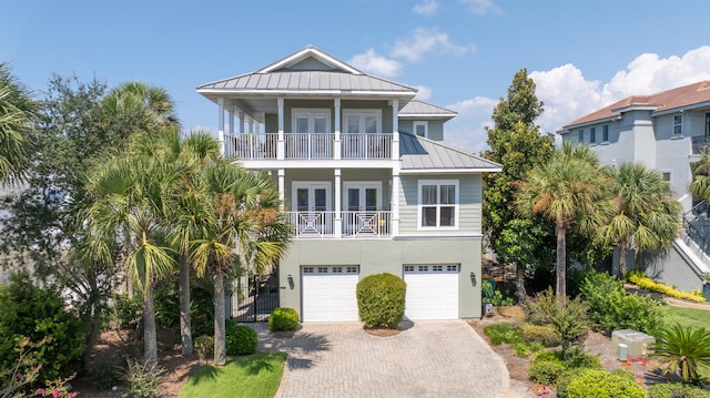 coastal inspired home with a garage and a balcony