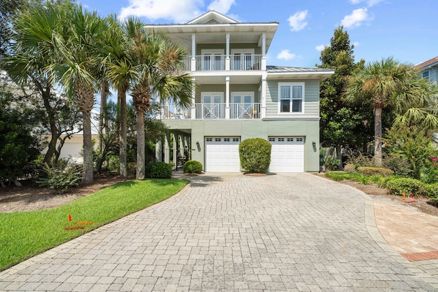 coastal home featuring a balcony and a garage