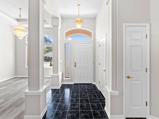 foyer entrance with decorative columns and a chandelier