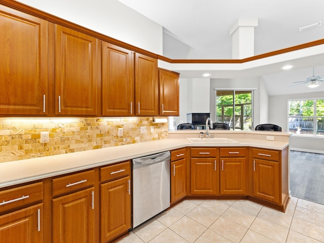 kitchen with kitchen peninsula, decorative backsplash, dishwasher, and sink