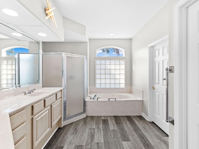 bathroom with hardwood / wood-style flooring, vanity, and shower with separate bathtub