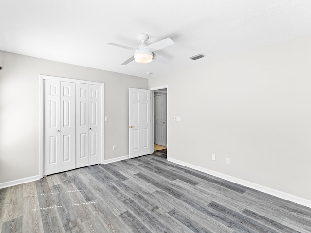 unfurnished bedroom featuring light hardwood / wood-style flooring, ceiling fan, and a closet