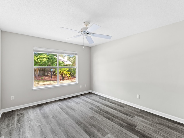 spare room featuring ceiling fan, dark wood-type flooring, and a textured ceiling