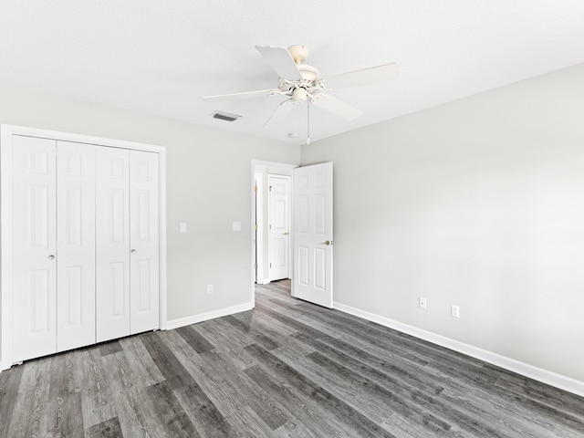 unfurnished bedroom featuring a closet, dark wood-type flooring, and ceiling fan