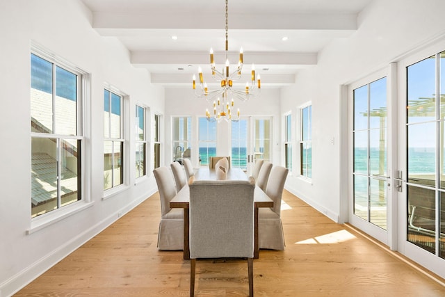 sunroom featuring beamed ceiling, a water view, an inviting chandelier, and french doors