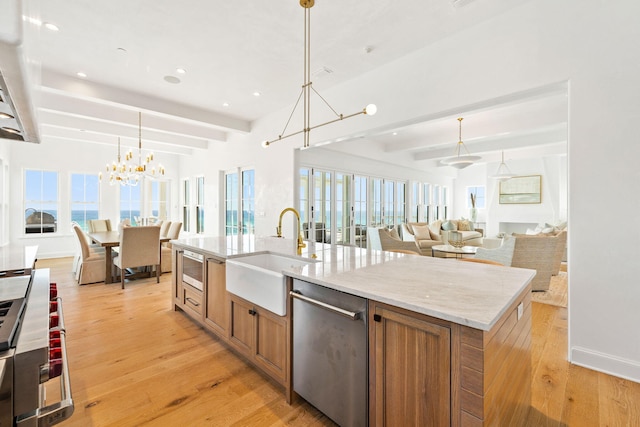 kitchen featuring sink, dishwasher, hanging light fixtures, an island with sink, and an inviting chandelier