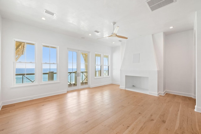 unfurnished living room with light hardwood / wood-style flooring, ceiling fan, and plenty of natural light