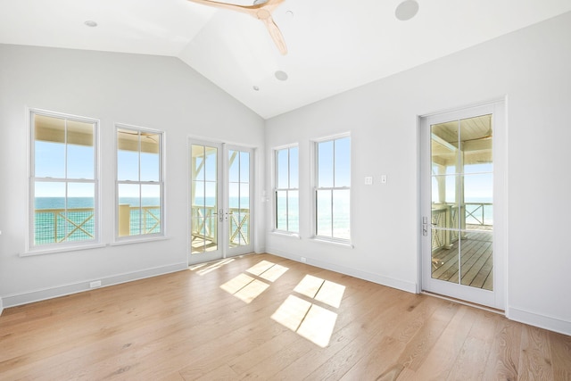 unfurnished room featuring light wood-type flooring, french doors, a water view, ceiling fan, and lofted ceiling