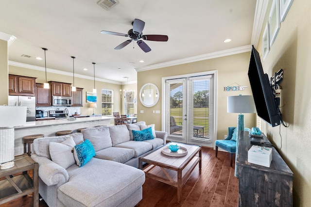 living room with ornamental molding, dark hardwood / wood-style flooring, and ceiling fan