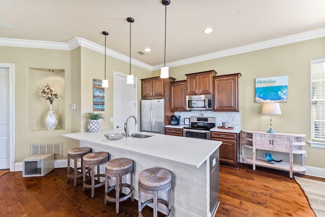 kitchen with hanging light fixtures, a breakfast bar area, stainless steel appliances, dark hardwood / wood-style floors, and ornamental molding